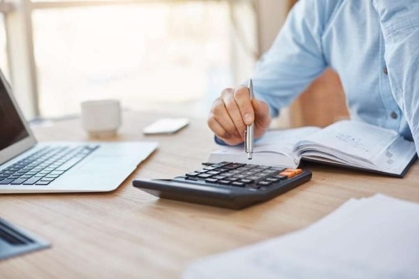 close-up-detail-professional-serious-accountant-sitting-light-office-checking-company-finance-profits-calculator(1)